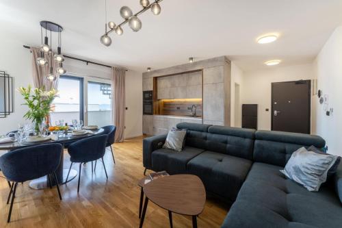 a living room with a blue couch and a table at Luxury Penthouse ARIA in Zadar