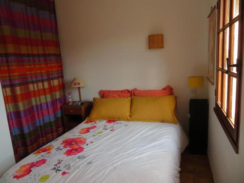 - une chambre dotée d'un lit avec des oreillers jaunes et rouges dans l'établissement Villa au calme avec piscine, au Luc