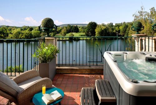 a hot tub on a patio with a view of the water at La Côte Saint Jacques in Joigny
