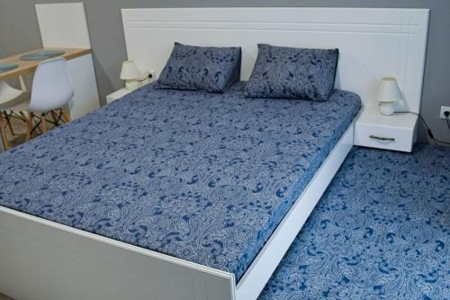 a bed with blue sheets and pillows in a bedroom at Art Studio Sea in Shkorpilovtsi