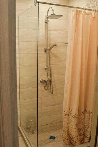 a shower with a glass shower curtain in a bathroom at Art Studio Sea in Shkorpilovtsi