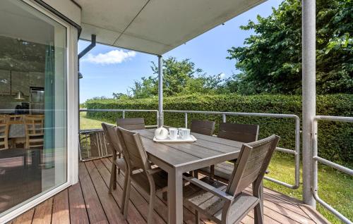 een houten tafel en stoelen op een terras bij Gudhjem Søpark Lejl 25 in Gudhjem