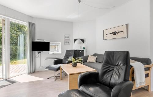 een woonkamer met een bank en een tafel bij Gudhjem Søpark Lejl 25 in Gudhjem