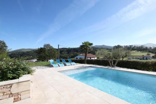 a swimming pool with two chairs and a swimming pool at Hergarai in Saint-Jean-le-Vieux