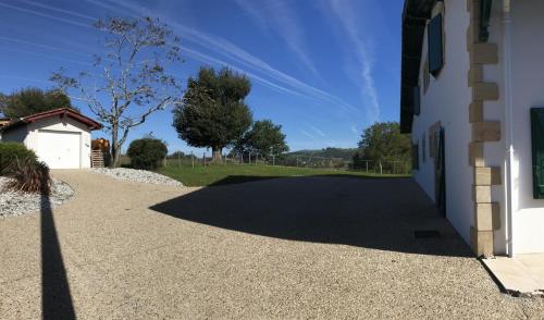 a driveway next to a white building at Hergarai in Saint-Jean-le-Vieux