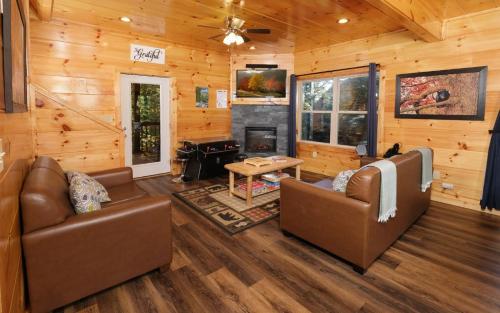 a living room with couches and a fireplace in a log cabin at Liberty Haven in Pigeon Forge