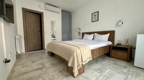 ein Schlafzimmer mit großem Bett und Holzboden in der Unterkunft Vila Blanc in Costinești