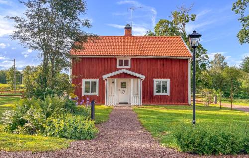 a red barn with a white door and a street light at Beautiful Home In Ydre With Wifi in Basarp