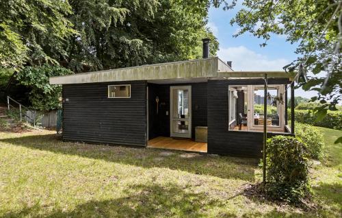 a small black tiny house with a porch at Gorgeous Home In Rødekro With Wifi in Rødekro