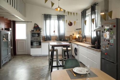 une cuisine avec une table, des chaises et un réfrigérateur dans l'établissement Maison Senlis jardin, à Senlis