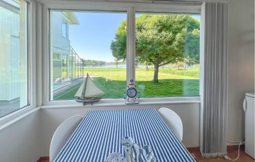 a window with a table and a sailboat in a room at Stunning Home In Södertälje in Södertälje