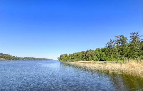 a large lake with trees on the side of it at Stunning Home In Södertälje in Södertälje