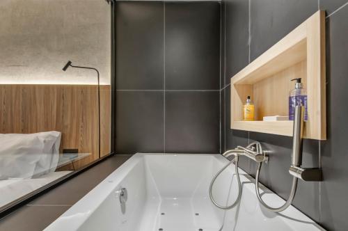 a bathroom with a bath tub and a sink at Noru Hotel Malta - Adults Only Hotel in St Julian's