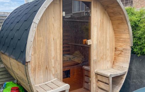 Una gran caseta de madera para perros con una silla dentro en Amazing Apartment In Egmond Aan Zee, en Egmond aan Zee