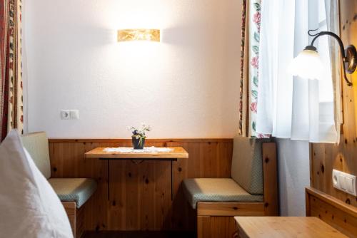a room with two chairs and a table and a window at Hotel Pension Odles in San Martino in Badia