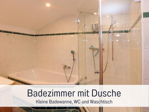 a bathroom with a tub and a shower with the words baxterimimeter hit at Ferienhaus BirkenOASE - Sauna- Terrasse-drei Schlafzimmer in Bad Heilbrunn