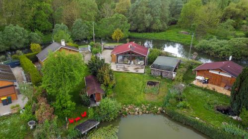 an aerial view of a large house with a pond at KÄBANE 81, Lodge avec spa au bord de l'eau in Prouilly