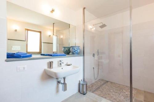 a white bathroom with a sink and a shower at SAN LEO, Castellabate - Mafalda in Castellabate