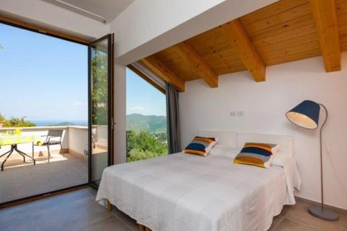 a bedroom with a bed and a large window at SAN LEO, Castellabate - Mafalda in Castellabate