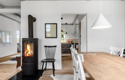 a living room and dining room with a wood stove at 3 Bedroom Amazing Home In Stege in Stege