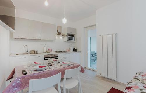 a kitchen with a table and chairs and a kitchen with white cabinets at Gorgeous Apartment In Recco in Recco