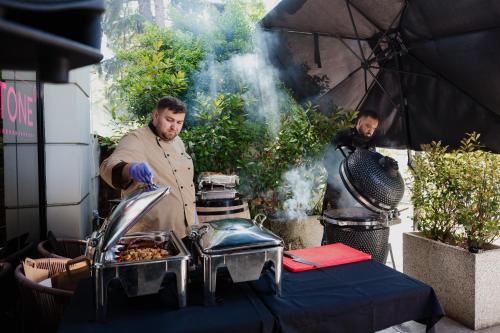 two men standing in front of a table with food at Mercure Timisoara in Timişoara