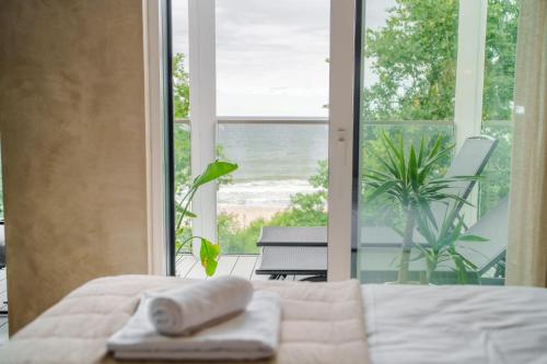 a bedroom with a bed and a view of the beach at Boho z Widokiem na Morze by Perłowa Przystań Rent in Sianozety