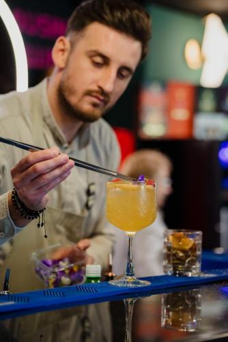 a man sitting at a bar with a drink at Mercure Timisoara in Timişoara