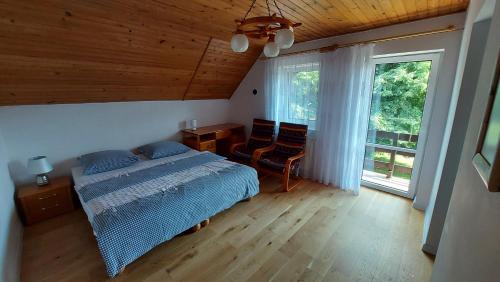 En eller flere senge i et værelse på Mazurskie Zacisze - sauna, jacuzzi, kominek