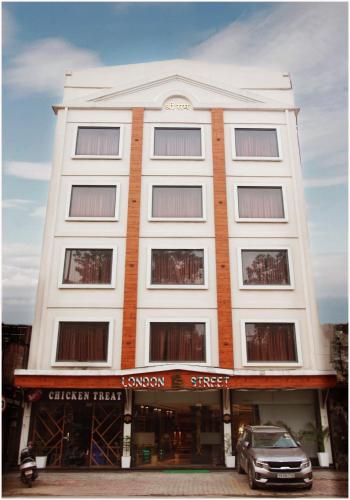 a white building with a car parked in front of it at TreeHouse London Street Amritsar in Amritsar