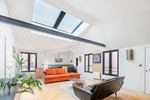 パリにあるLuxury Flat with AC "La-verrère-du-paradis"のリビングルーム(オレンジ色のソファ付)