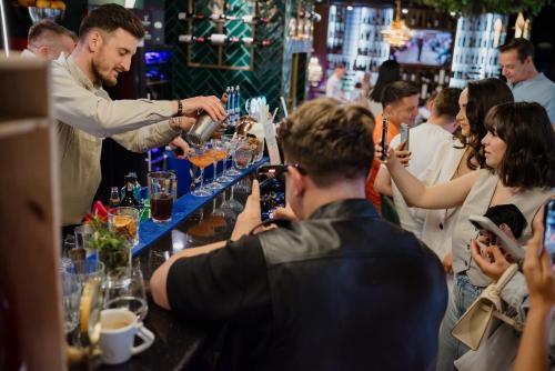 a man is serving drinks at a bar at Mercure Timisoara in Timişoara