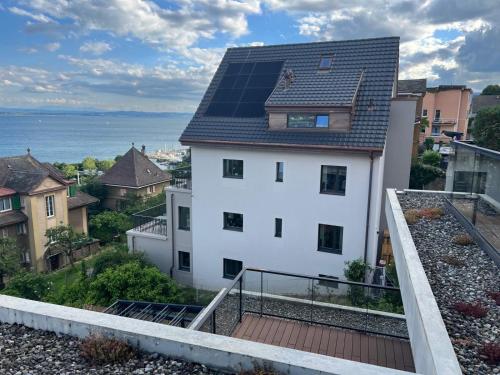 Casa blanca con paneles solares en el techo en Mail 62, en Neuchâtel