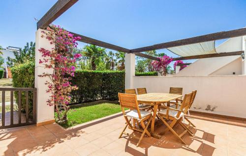 a table and chairs on a patio with flowers at Nice Apartment In Alhama De Murcia in Alhama de Murcia