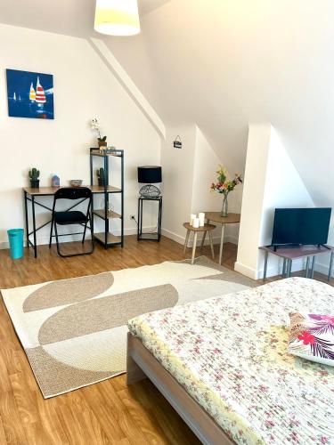 a bedroom with a bed and a table and chairs at Chambre avec cuisine à la campagne au calme in Cléguérec