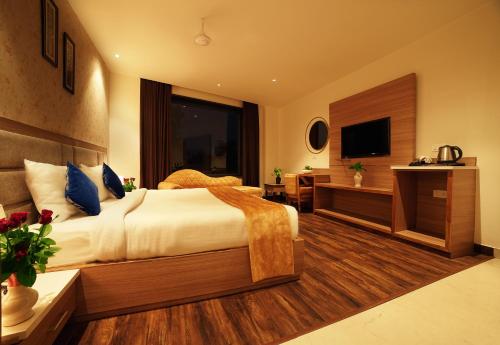 a hotel room with a bed and a television at TreeHouse London Street Amritsar in Amritsar