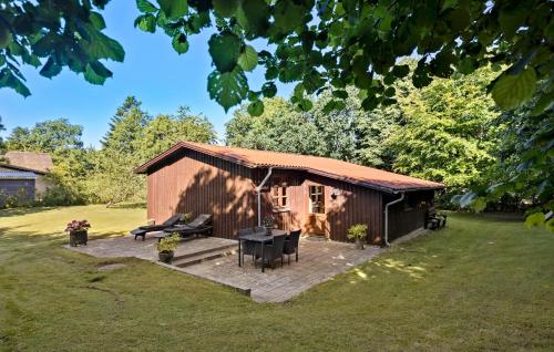 a barn with a table and chairs in a yard at 3 Bedroom Nice Home In Farsø in Farsø