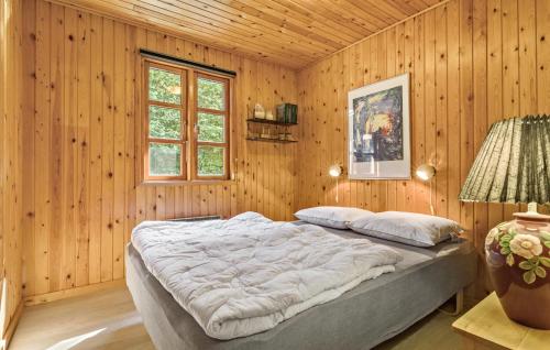 a bedroom with a large bed in a wooden wall at 3 Bedroom Nice Home In Farsø in Farsø