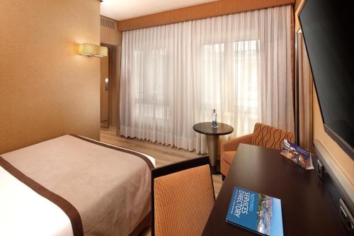 a hotel room with a bed and a table and a window at HCC St. Moritz in Barcelona