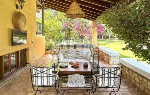 a patio with a table and chairs and a couch at Pet Friendly Home In Astros Arkadia in Astros