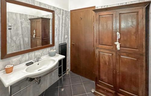 a bathroom with a sink and a wooden cabinet at Pet Friendly Home In Astros Arkadia in Astros