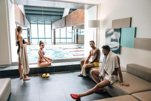 a group of people sitting around a swimming pool at Aparthotel Maso Corto in Maso Corto