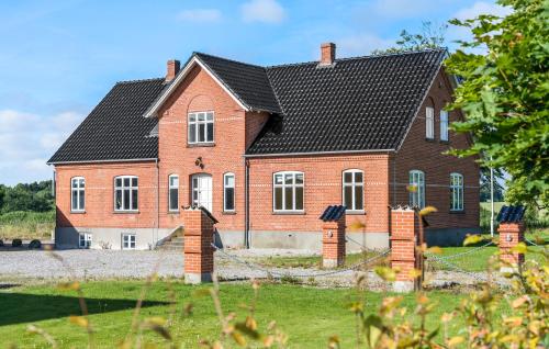 a red brick house with a black roof at 5 Bedroom Nice Home In Nyborg in Nyborg
