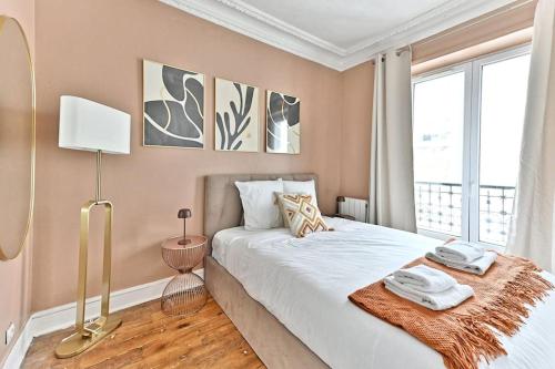 une chambre avec un grand lit et une fenêtre dans l'établissement Appartement cosy et coloré au cœur de Paris, à Paris