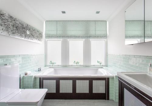 un bagno con vasca e lavandino di Large and luxurious country home near Glasgow a Eaglesham