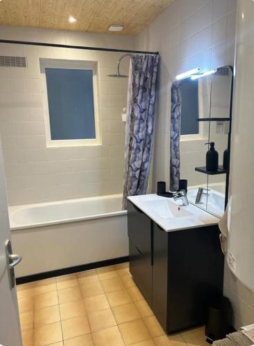 une salle de bain avec un lavabo et une baignoire dans l'établissement Enosis, à Port-en-Bessin-Huppain