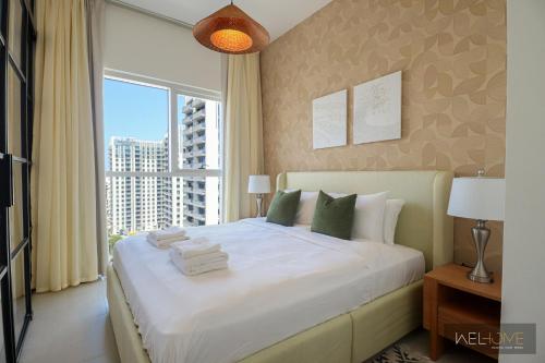 a bedroom with a large bed with a large window at WelHome - Fancy 1BR Apt at Dubai Hills near Dubai Hills Mall in Dubai