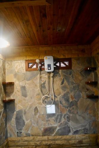 a shower in a room with a stone wall at Mai Pen Rai Bungalows in Than Sadet Beach