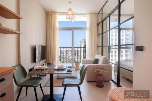 a living room with a couch and a table with chairs at WelHome - Fancy 1BR Apt at Dubai Hills near Dubai Hills Mall in Dubai