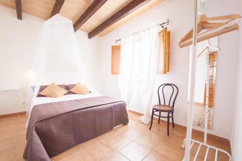 a bedroom with a bed and a chair at Ses Canyes in Muro